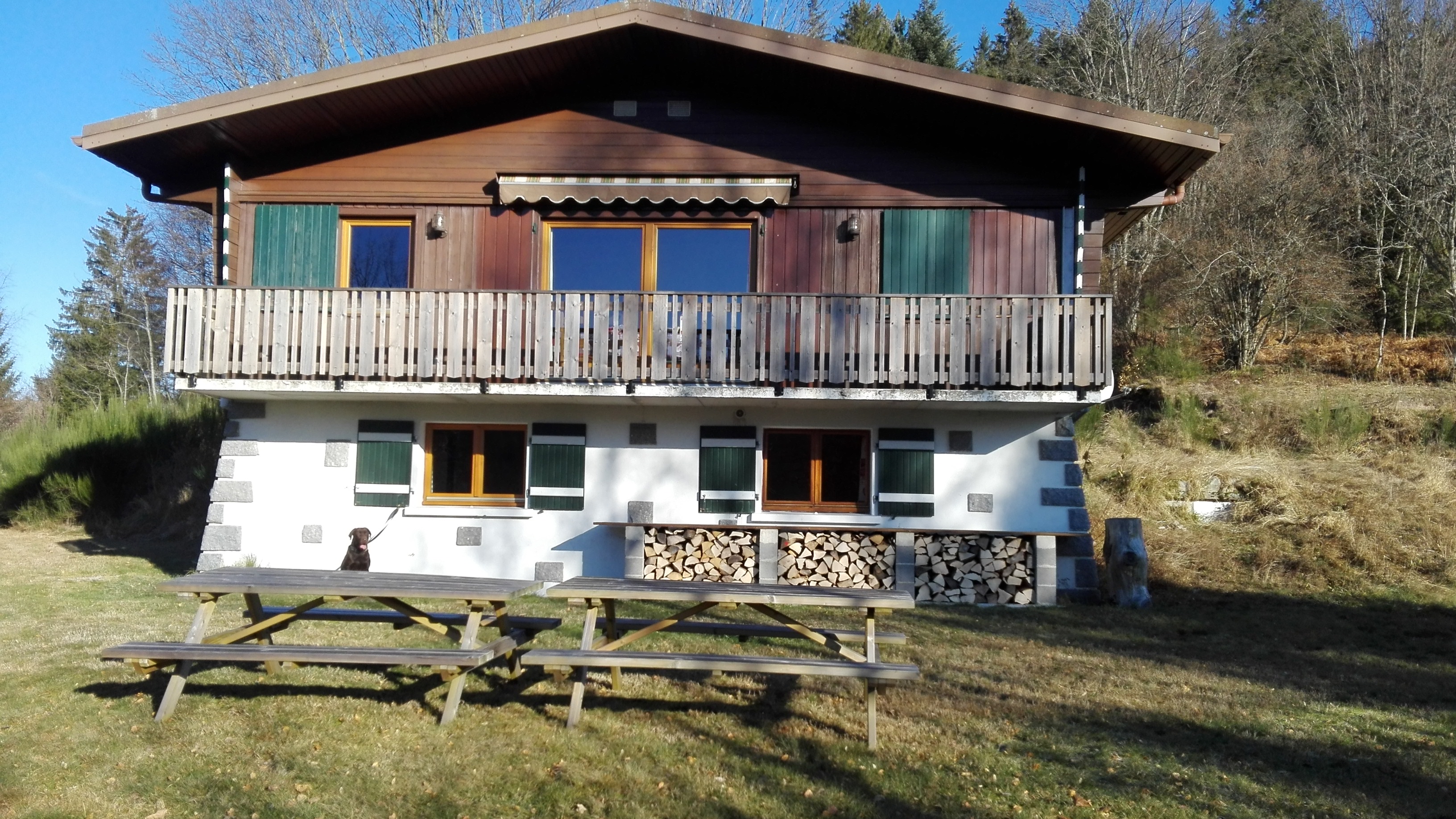 L’avant du chalet, où se trouve le bois et les tables de jardin