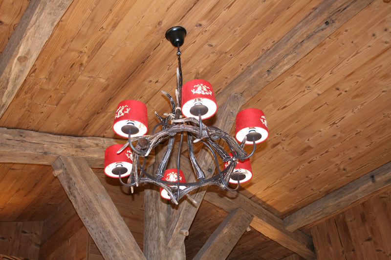 Le lustre en bois et la charpente du chalet